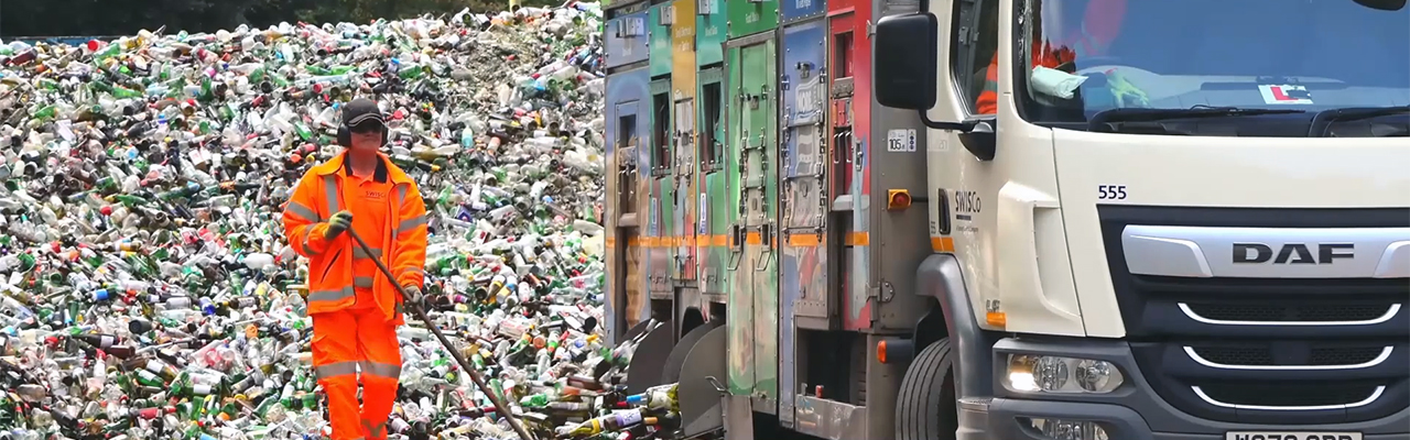 SWISCo crew at the recycling centre with pile of glass bottles and vehicle